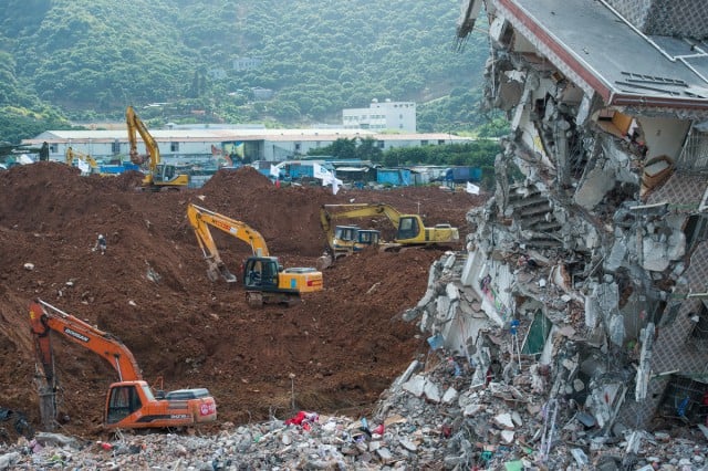 Excavators are used to dig through mud at the site of the landslide, which hit the Hengtaiyu, Liuxi and Dejicheng industrial parks, in Hongao village, Shenzhen city, south China's Guangdong province.