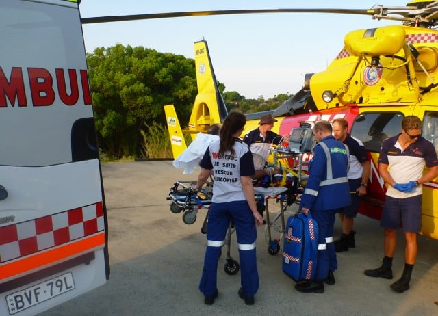 Ambulance paramedics and the Rescue Helicopter medical team treat a man who fell from a ladder at Woodenbong.