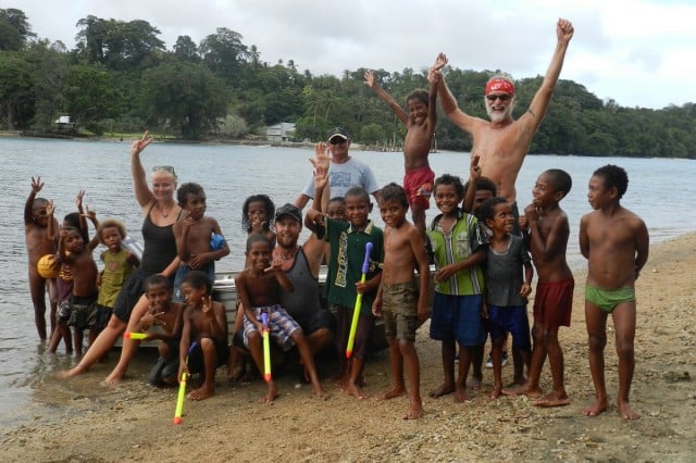 Pick the locals (l to r) Siobhan Quaine, Todd Pearce, Gary Richards and Mark Cochrane with some of the kids whose families benefited from a recent aid mission to The Louisiades and Trobriand Islands in Papua New Guinea. Photo Alison Cochrane