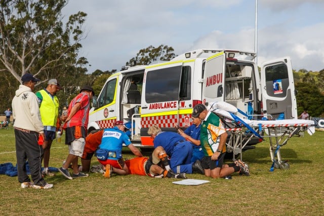 Paramedics prepare Fred Waters for a trip to Lismore Base with a badly broken leg during Sunday's grand final of the Aboriginal Knockout.