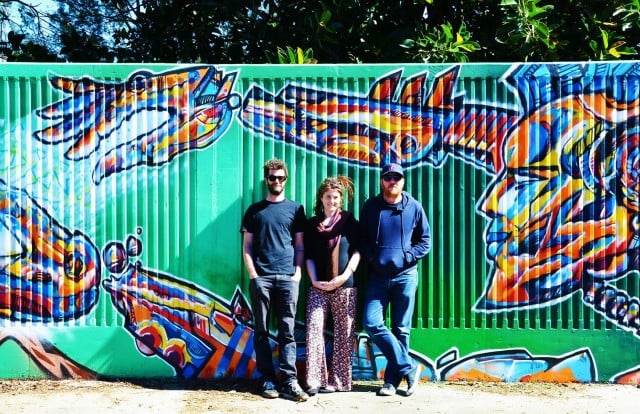 Artists Jeremy Austin and Justin Livingston (aka Julla) with Back Alley Gallery project manage) Erin Lewis at the new levee wall mural near the Lismore Skate Park. Photo supplied