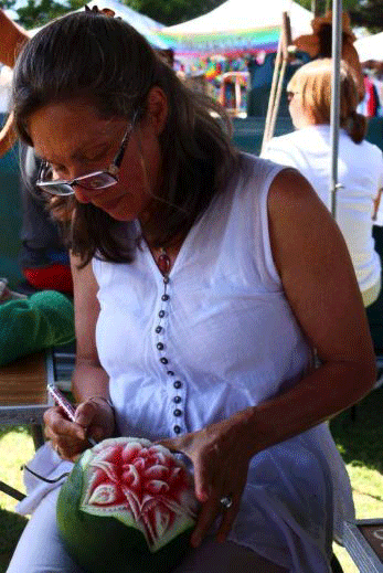 Gitta Radau carving a melon at a local market day.