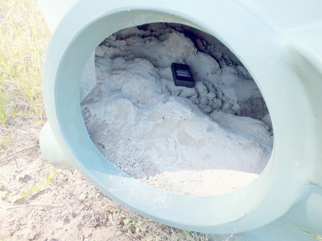 The overturned tank at Metgasco's decomissioned Corella  well at Dobies Bight with a geiger counter checking radiation levels. Photo Alan Roberts