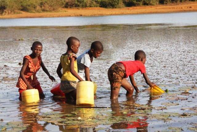 A still from the documentary: children collecting unsafe water from a dam in western Kenya. 