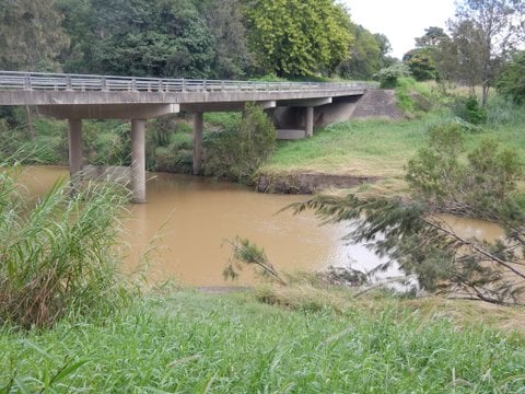 The brridge on the Oxley River downstream from Hopping Dick Creek showing the muddied water washing down after rainfall soon after the alleged illegal earthworks.