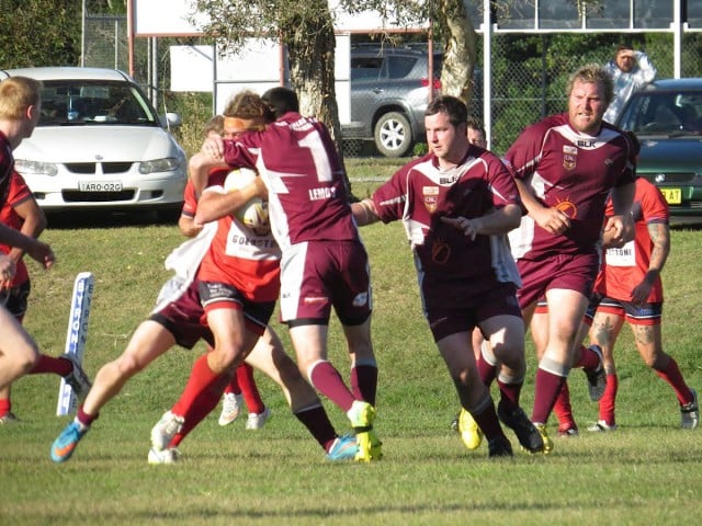 The Red Devils’ Joey McCarthy is caught in a tender embrace by the Casino Cougars.