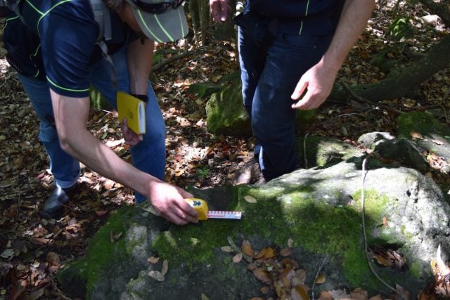 Archeologists examine what they say are granite rocks which have been used to sharpen tools or weapons. (Darren Coyne)