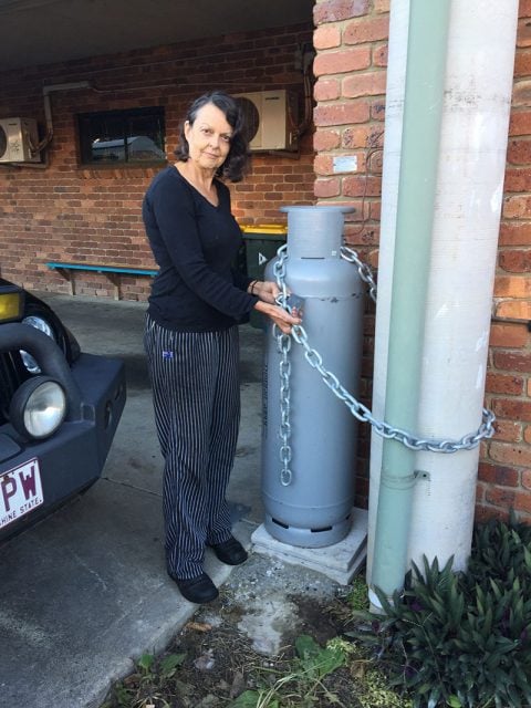 Lulu's Cafe proprietor Linda with the replacement 45kg bottle supplied by Origin. Thieves have cut through thick chains steeling several gas bottles in recent weeks. Photo Aslan Shand.