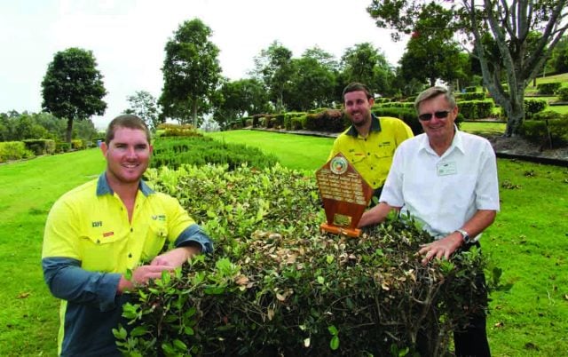 Tweed Shire Council Parks and Gardens ganger Danny Booth (left) and cemetery operator Kelvin Jordan receive the winner's trophy from Murwillumbah & District Garden Club representative Wayne Taggett. Photo Tweed Shire Council